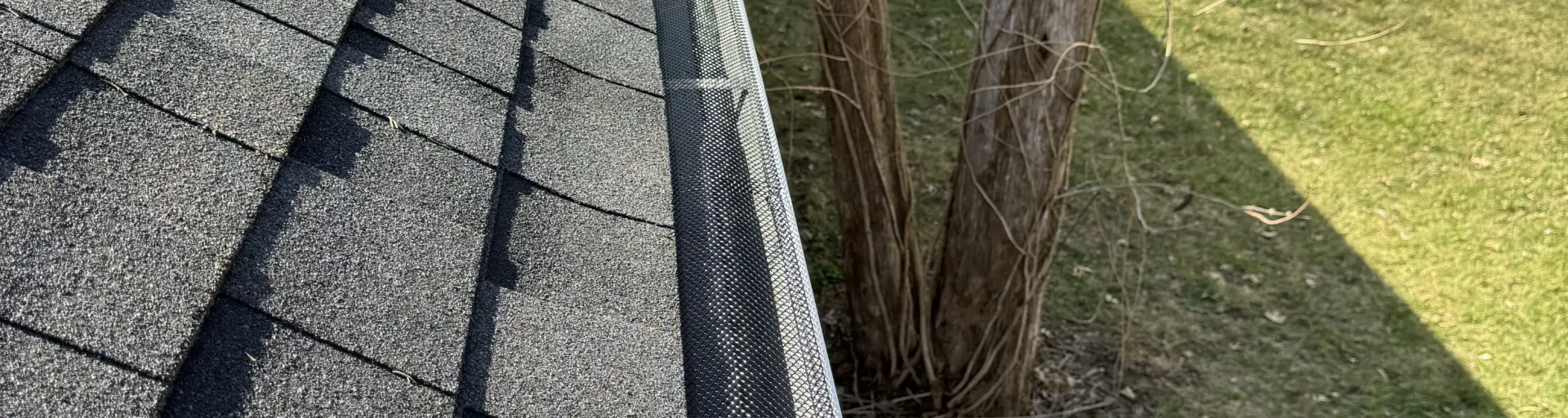 A photo of a customer's home with new roofing and gutters installed.